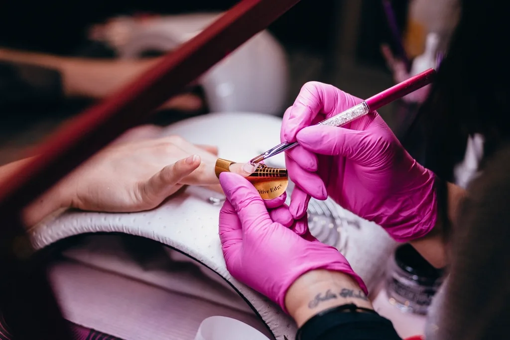 Manicurista pintando nail art con pincel